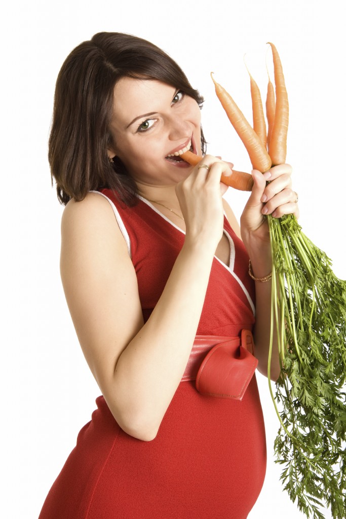 21 weeks happy pregnant woman with fresh carrots