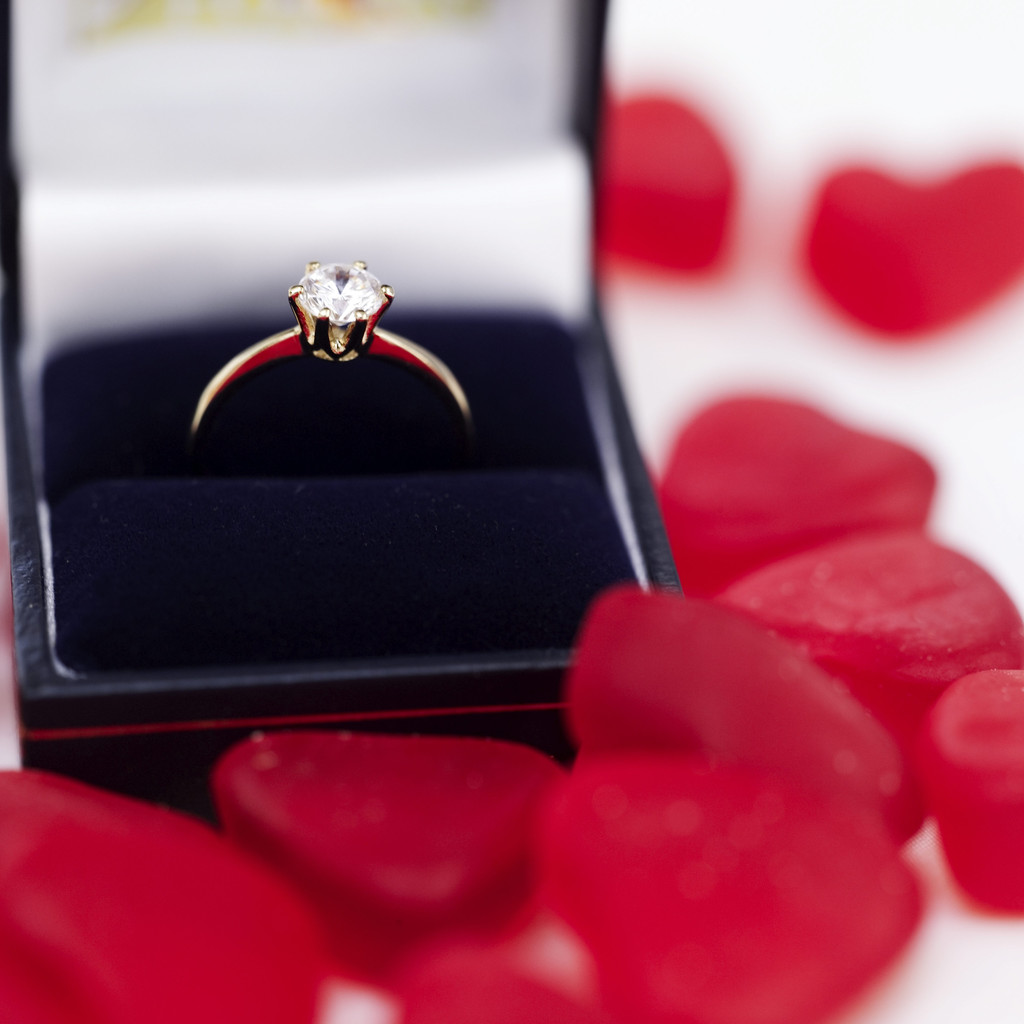 Red Heart Shaped Candies Surrounding an Engagement Ring in a Box