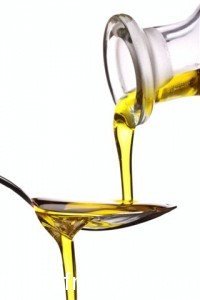 extra virgin olive oil being poured onto a spoon